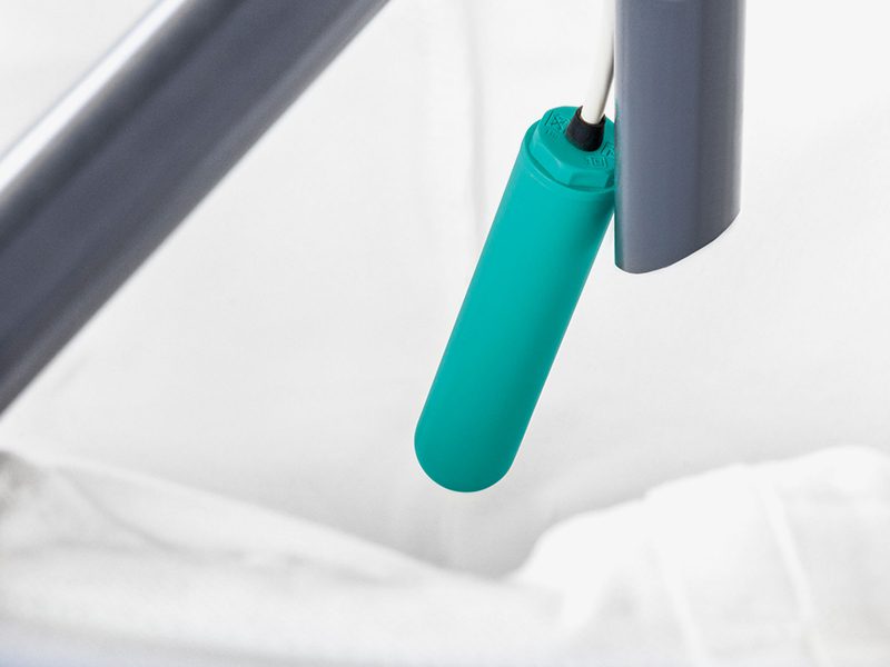 Small turquoise bed remote dangling beside rail
